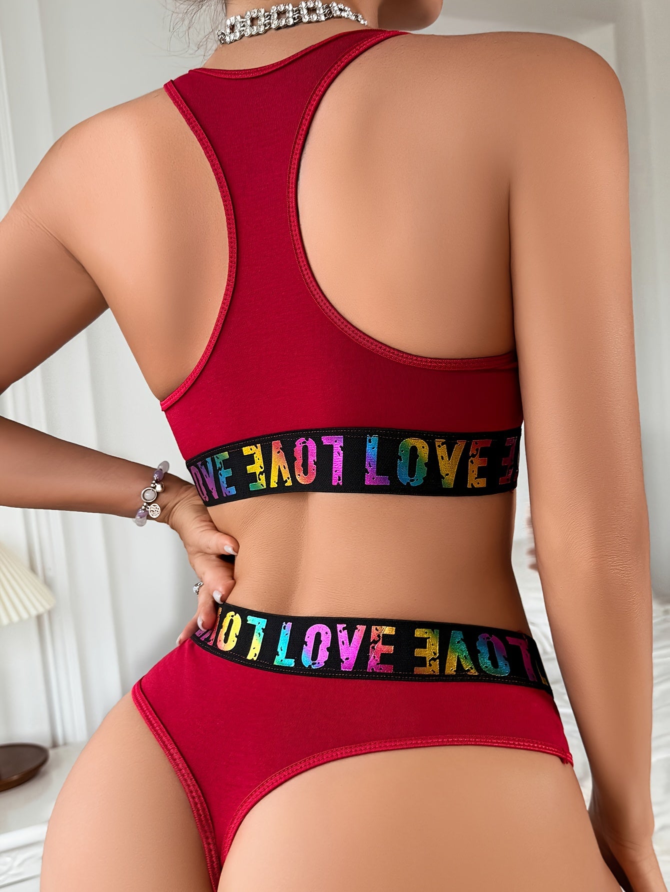 Conjunto de lencería de mujer con sujetador y tanga con aberturas y aros de corazón y estampado de letras: elegante y moderno.